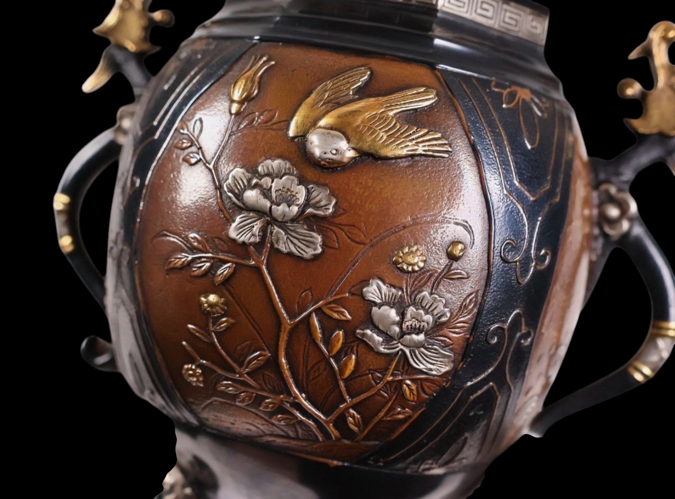 Takaoka bronze koro, close-up of metallic bird, flowers, and inlay details, part of a katana collection