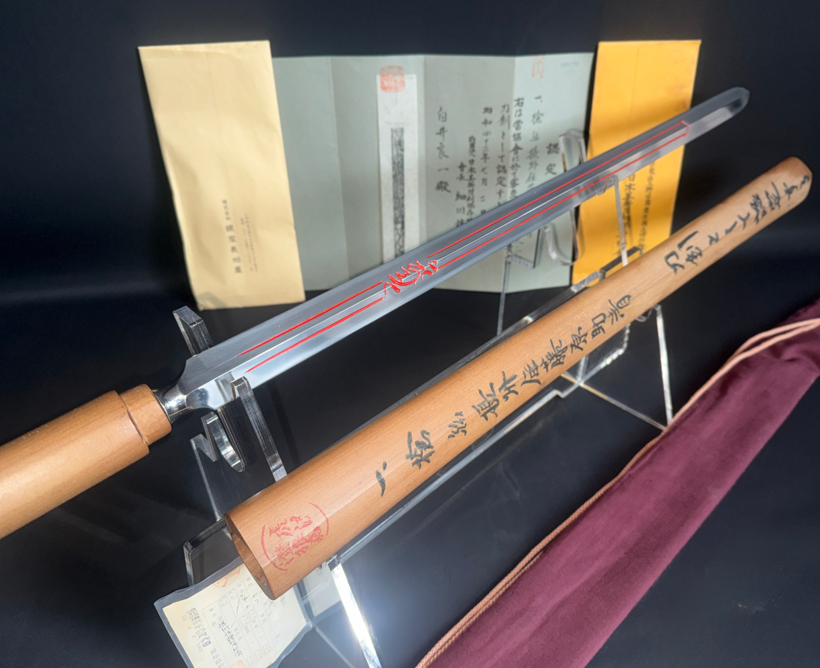 Exceptional Ōmi-Yari by Sukekiyo. Diagonal view of the Japanese antique yari blade with red engraving, partially in wooden shirasaya.