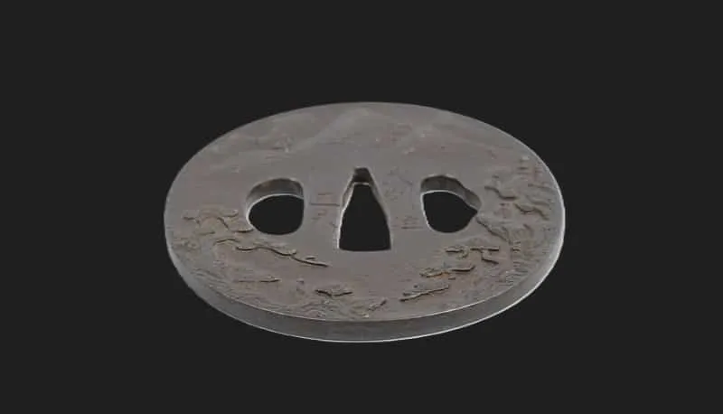Edo-Period Tsuba Busyu Masanaga sword guard, dark gray with subtle texture and cutouts, slightly angled view
