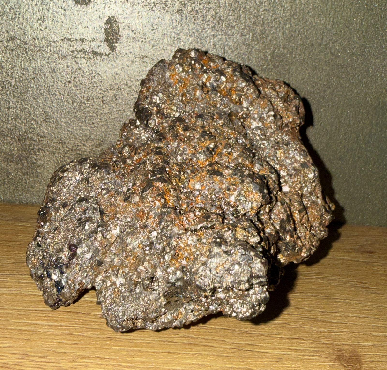 Rough, sparkling Japanese Tamahagane Steel accessory against a light wood surface, angled overhead.
