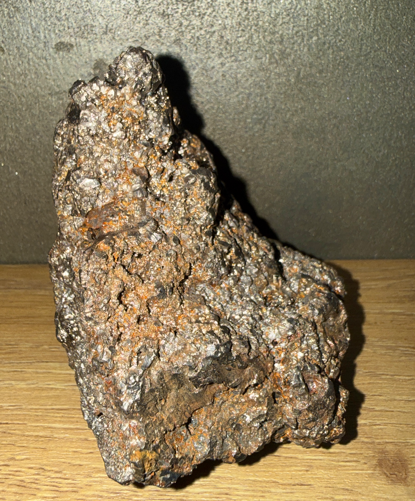 Jagged Japanese Tamahagane Steel accessory in natural light, showing metallic flecks and orange iron deposits