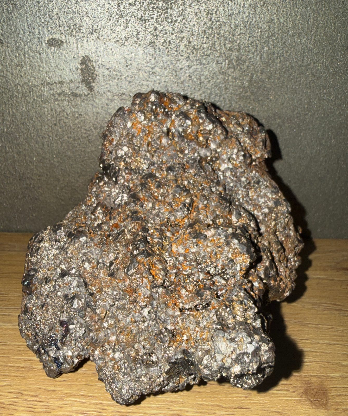 Rough, sparkling Japanese Tamahagane Steel accessory against a dark background, showing orange-rust accents.