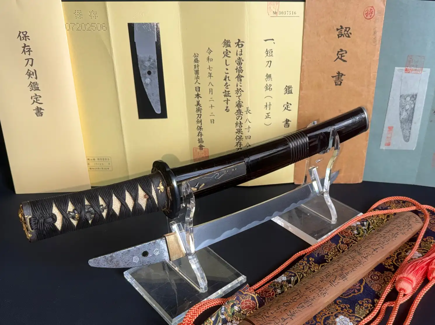 Kyodai Originals Nidai Muramasa Sayagaki Katana, blade, tang, and scabbard with papers on display