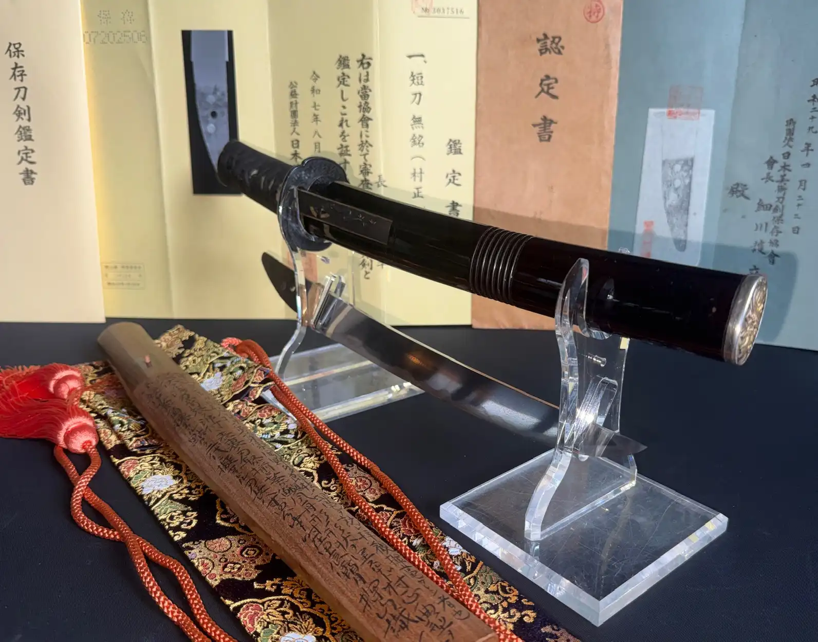 Kyodai Originals Nidai Muramasa Sayagaki Katana, blade partially sheathed, with wooden saya nearby.