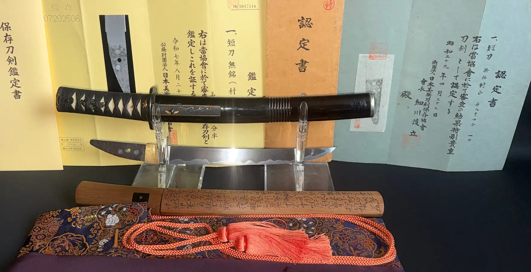 Kyodai Originals Nidai Muramasa Sayagaki katana with detailed handle and blade, certificates visible in background.