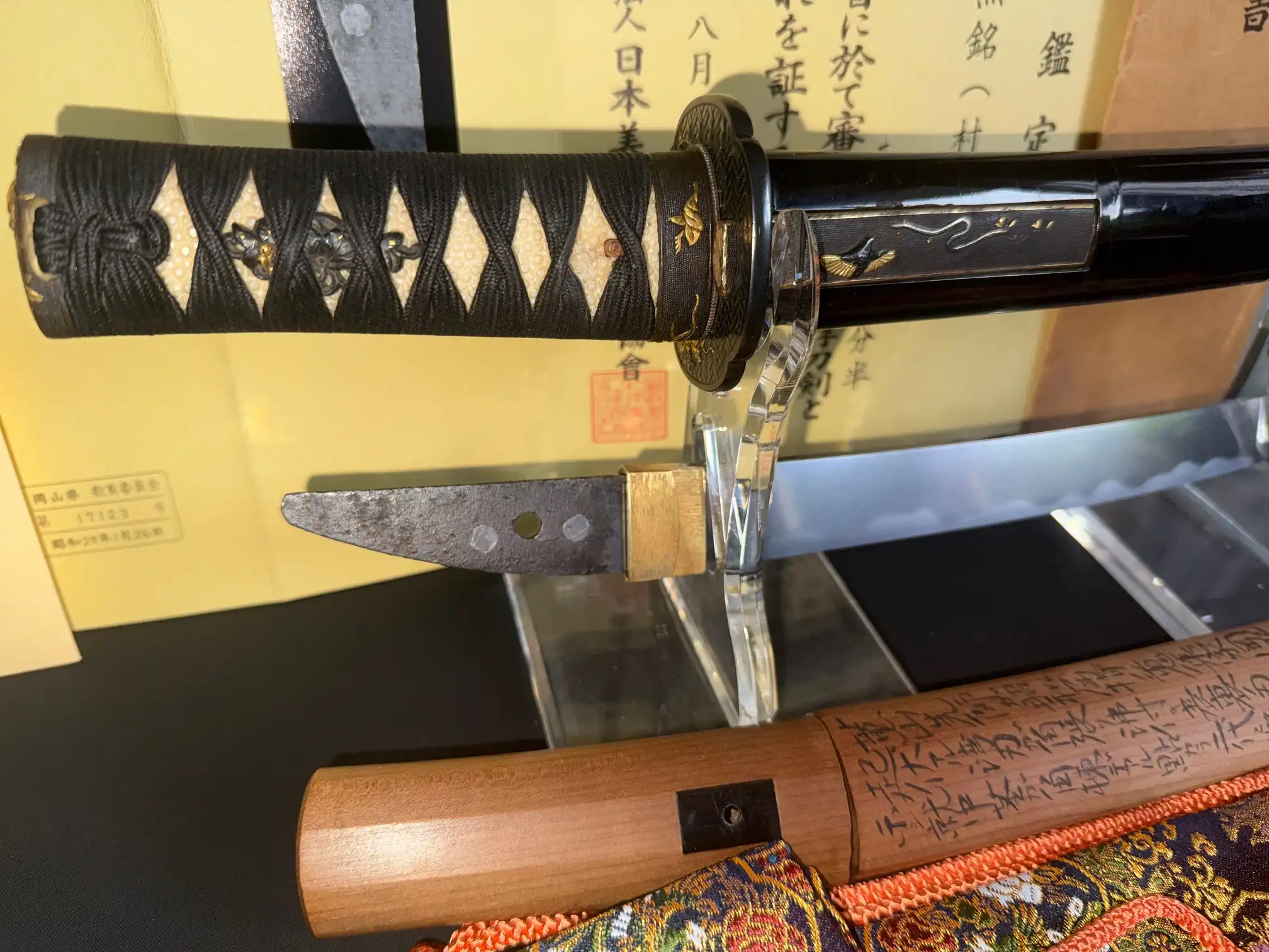 Kyodai Originals Nidai Muramasa Sayagaki Katana: close-up of handle and partial blade with papers foreground.