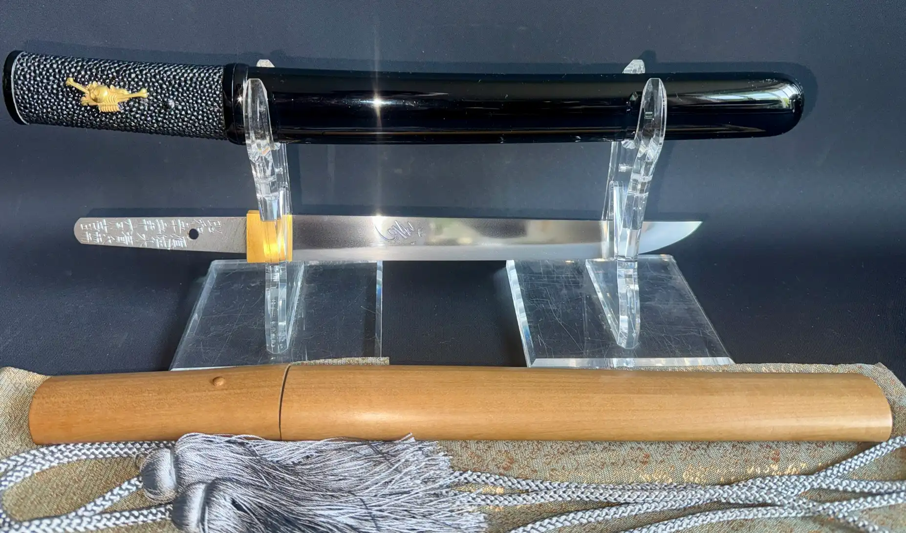 Ōno Yoshimitsu Mukansa Tantō (1980) on display with scabbard, showing signature and gold ornament.