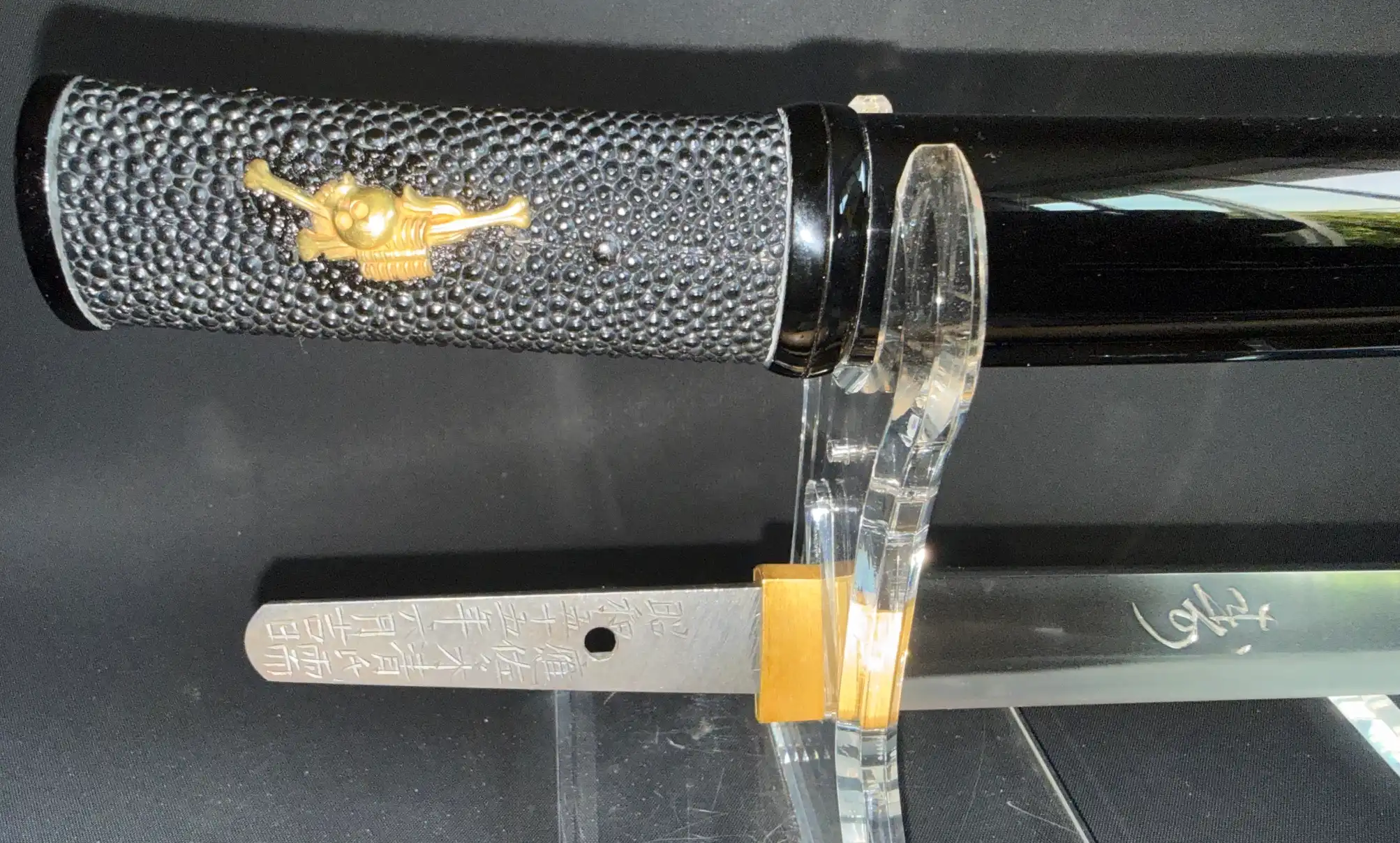 Ōno Yoshimitsu Mukansa Tantō with black ray skin handle, gold menuki, and visible tang inscription and signature.