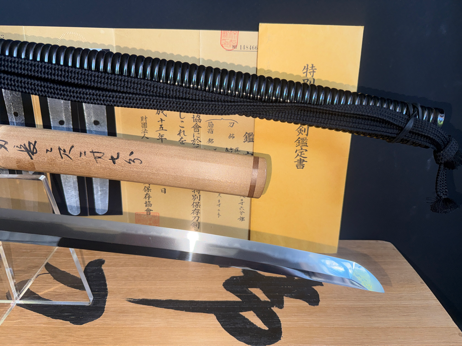 Naotane’s Final Known Daishō katana, with black braided cord handle and gleaming blade, documents in background
