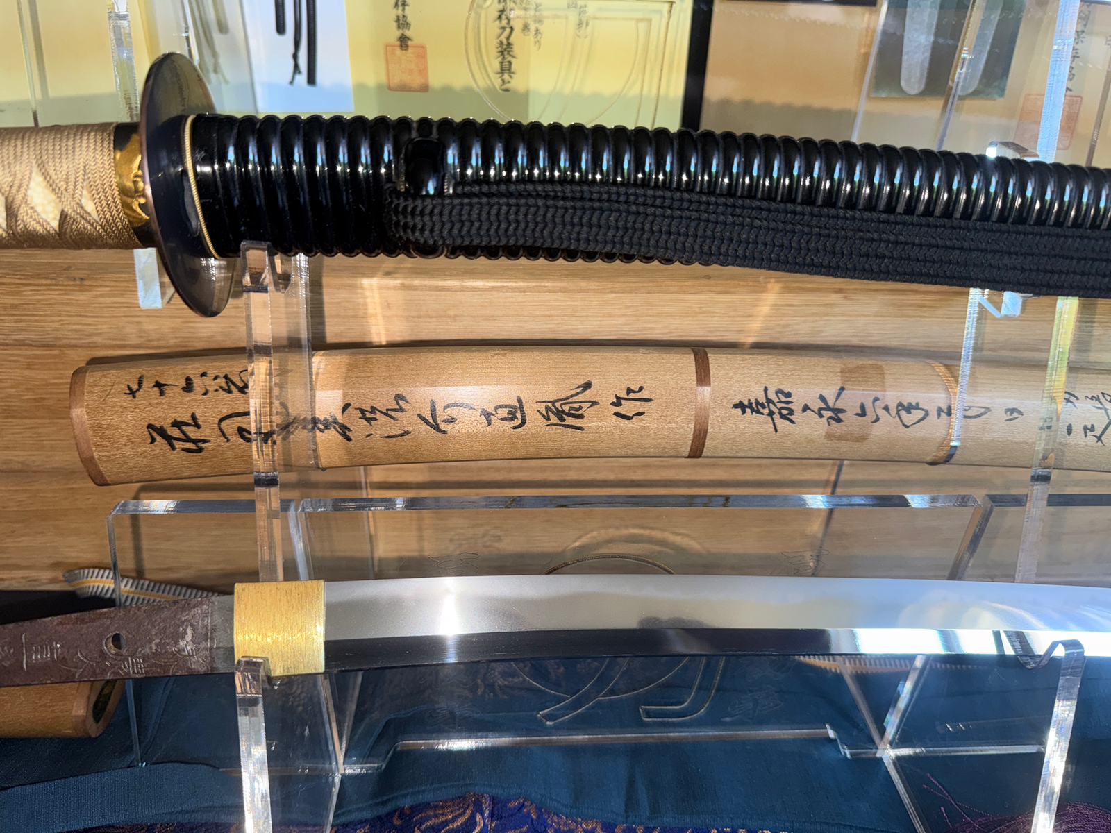 Close-up of Naotane’s Final Known Daishō katana showing hilt, inscribed wooden saya, and polished blade.