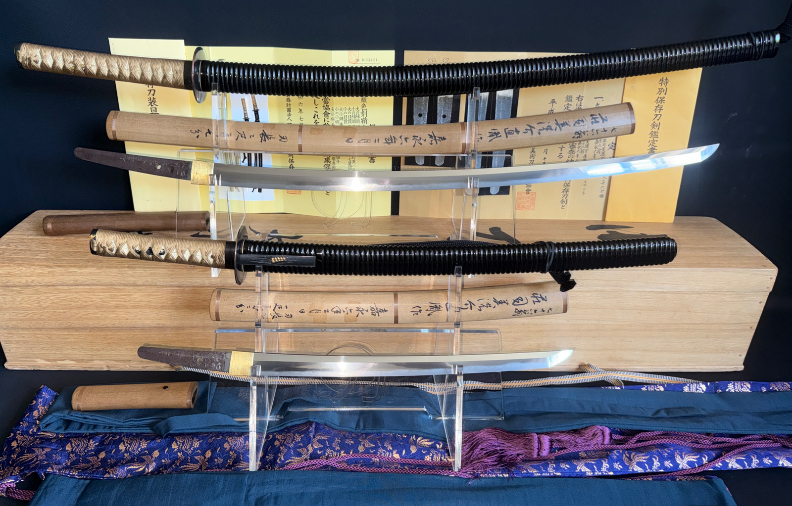 Naotane’s Final Known Daishō katana pair displayed in mounts, with blades unsheathed, paperwork visible