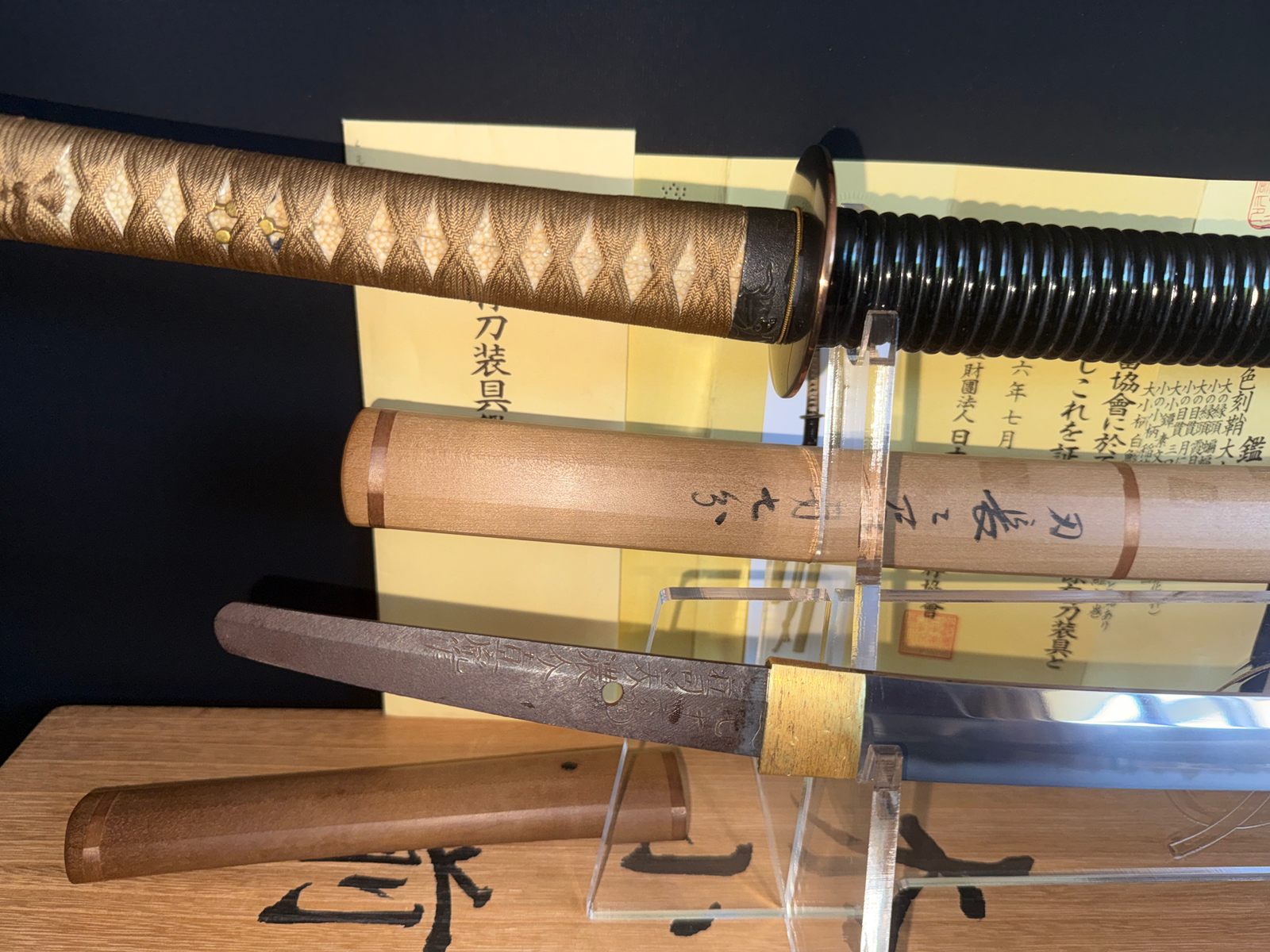 Taikei Naotane’s Final Known Daishō katana with ornate handle and wooden sheaths on display.