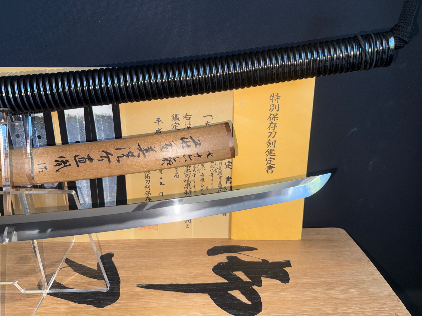Naotane's Final Known Daishō katana with black wrapped tsuka and polished blade, certificate in background