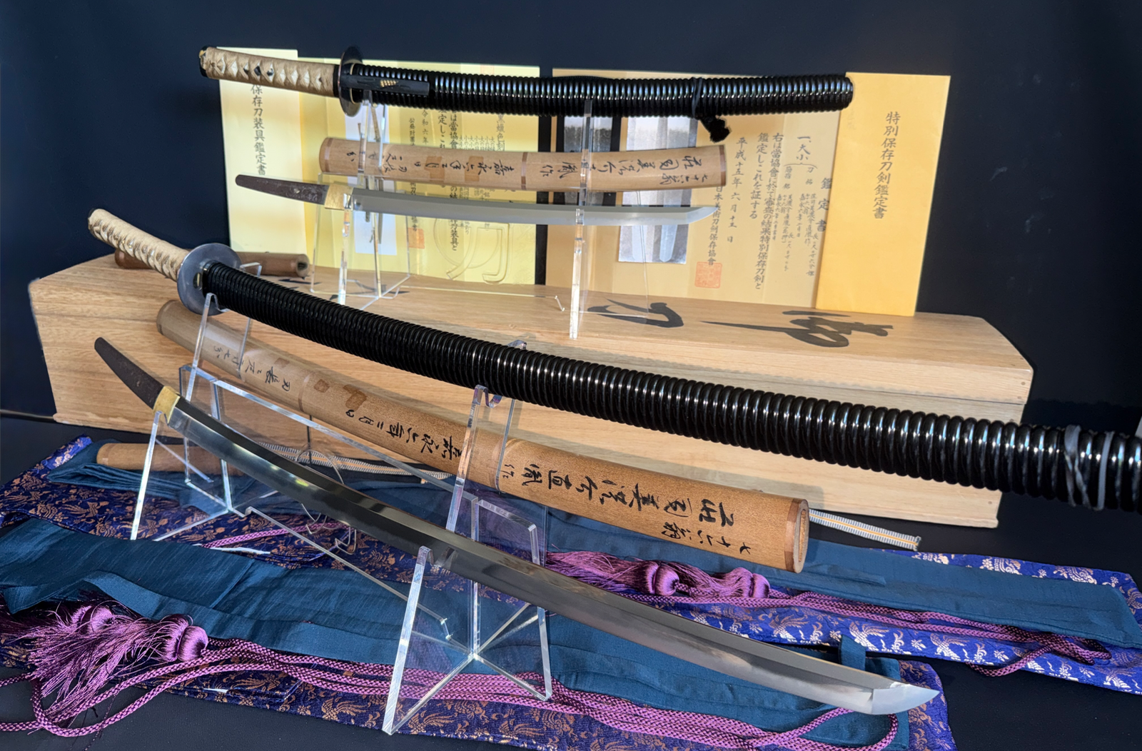 Two antique Naotane's Final Known Daishō katana swords with documentation on stands, front angle
