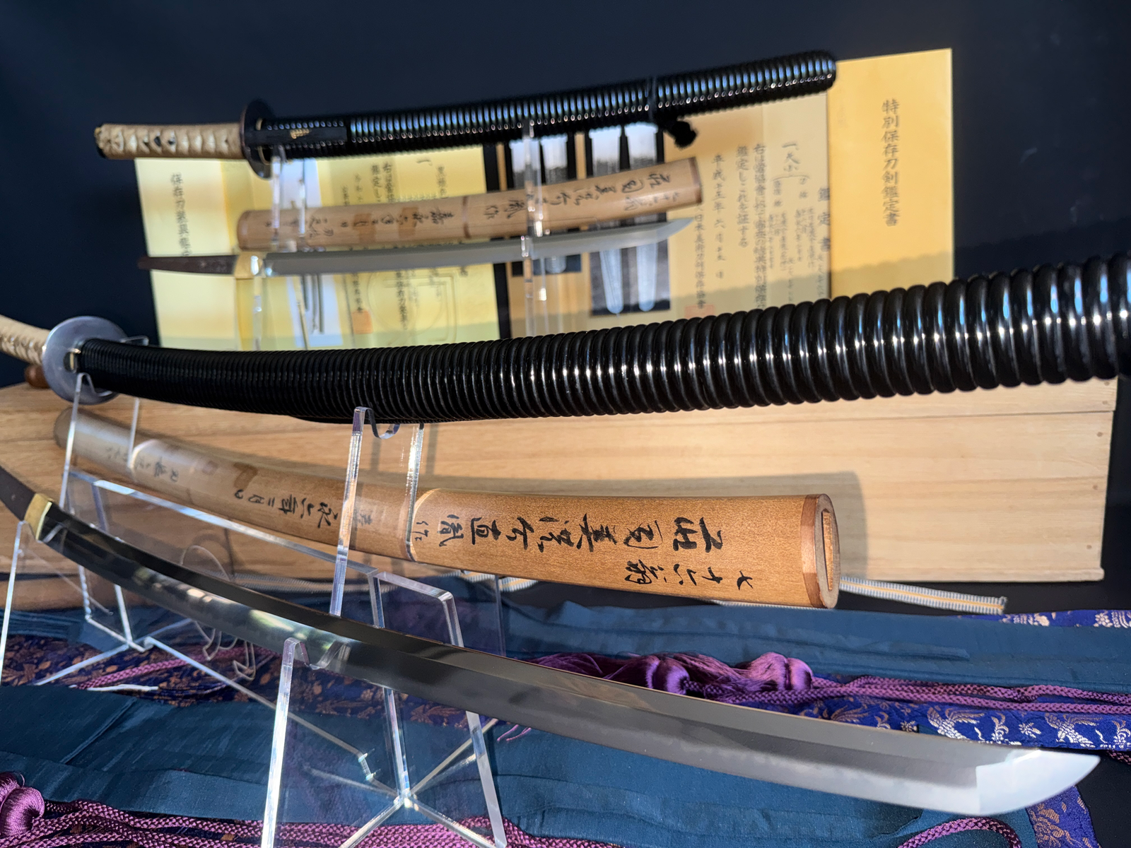 Naotane's Final Known Daishō katana blades and handles on stands with certificates, top-down view