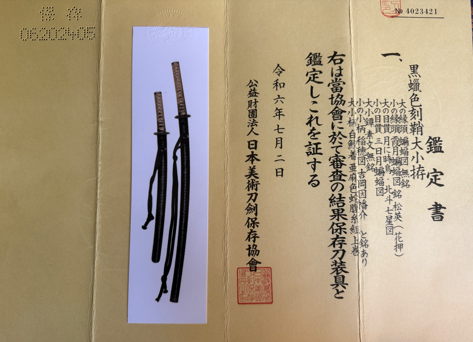 Two Naotane’s Final Known Daishō katana swords with dark sheaths and intricately wrapped handles, beside a certificate