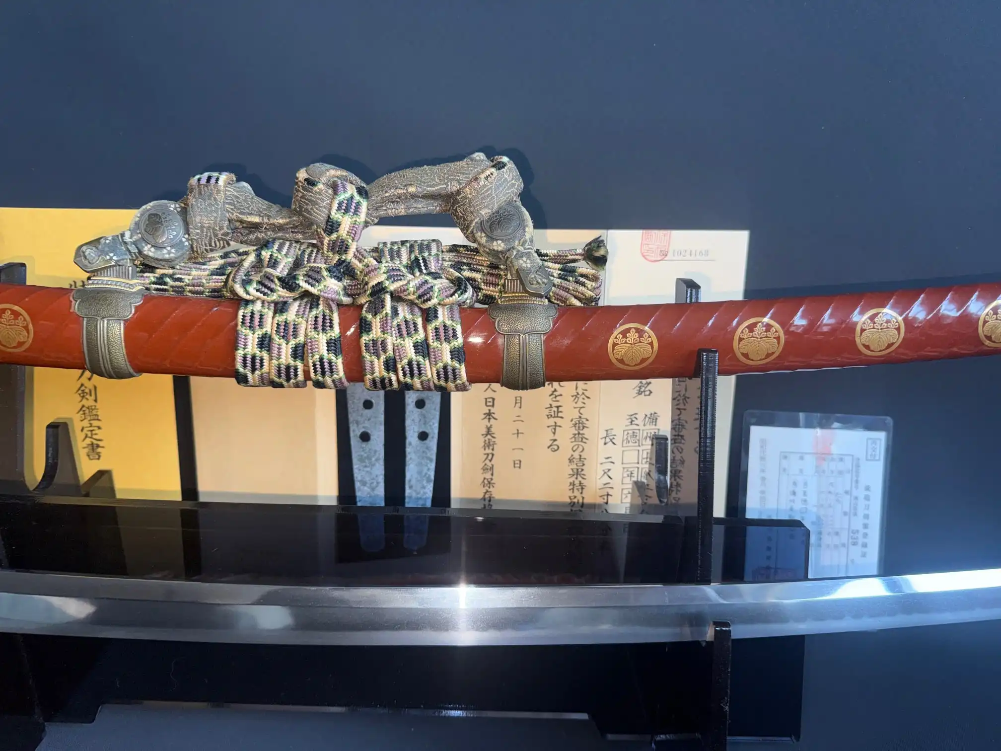 Nanbokuchō Tachi Hidemitsu katana, red lacquered saya with gold mon, intricate sageo and koiguchi displayed.
