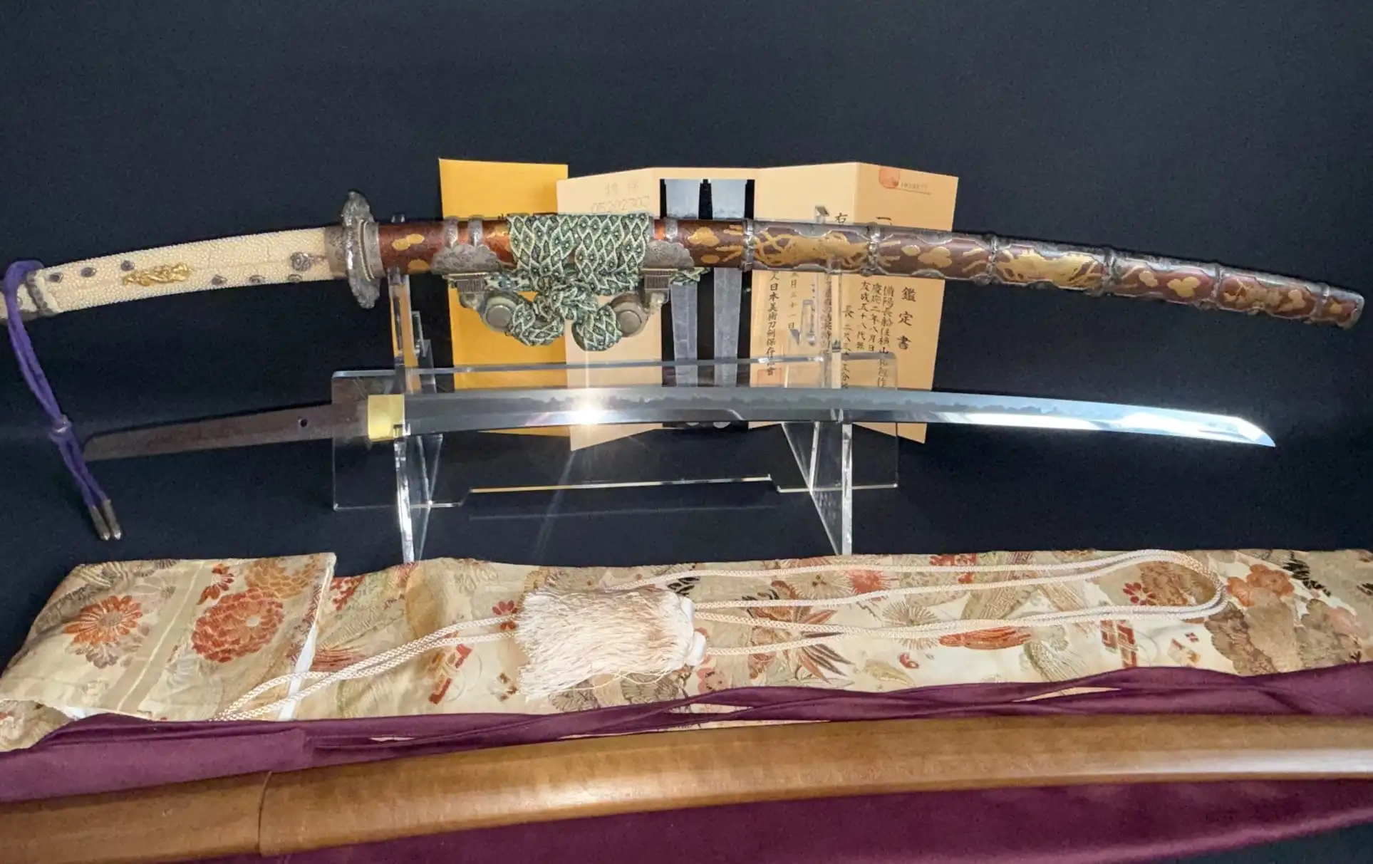 Tachi Yokoyama Sukekane Katana with ornate saya, full view and bright blade on display stand.