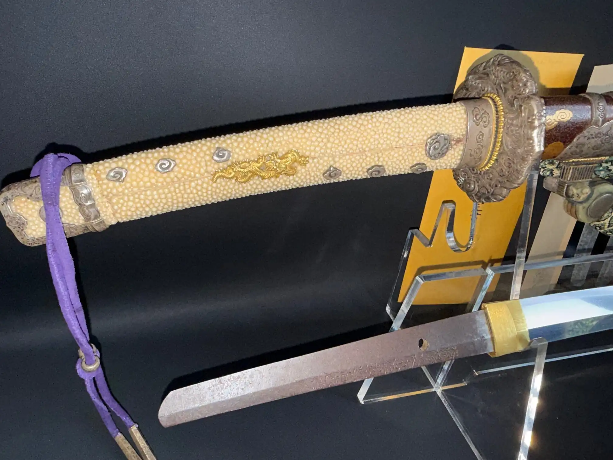 Tachi Yokoyama Sukekane katana, stingray skin handle, golden dragon motif, and visible blade on display