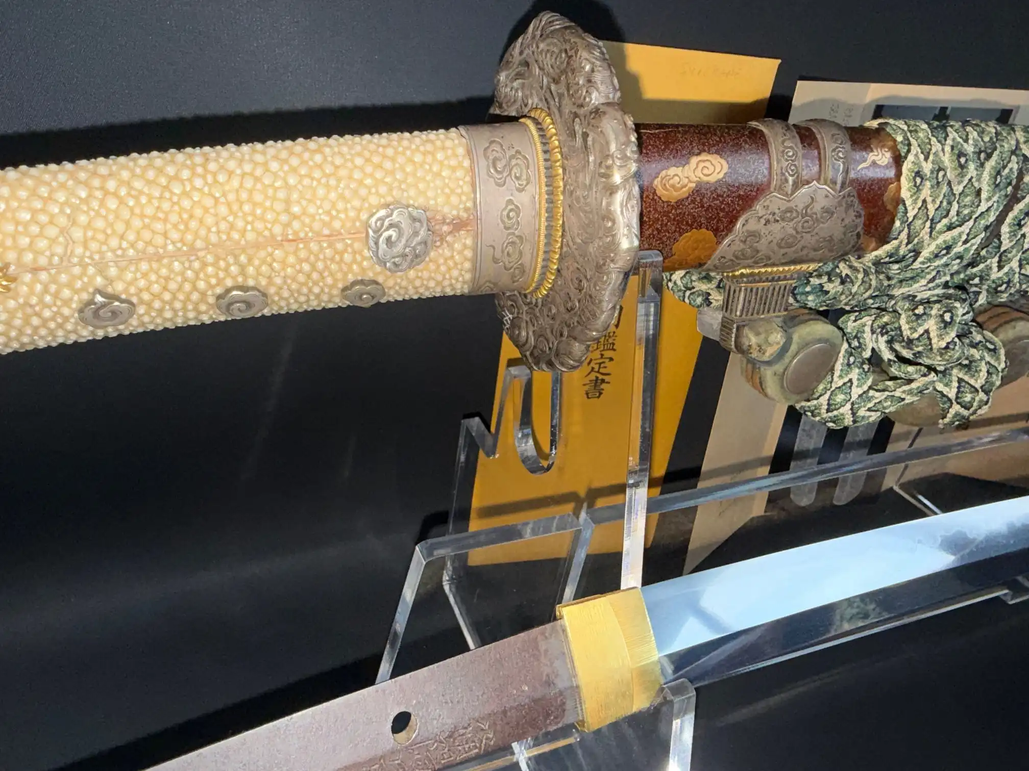 Close-up of Tachi Yokoyama Sukekane Katana with hilt, ray skin handle, and visible blade on display.