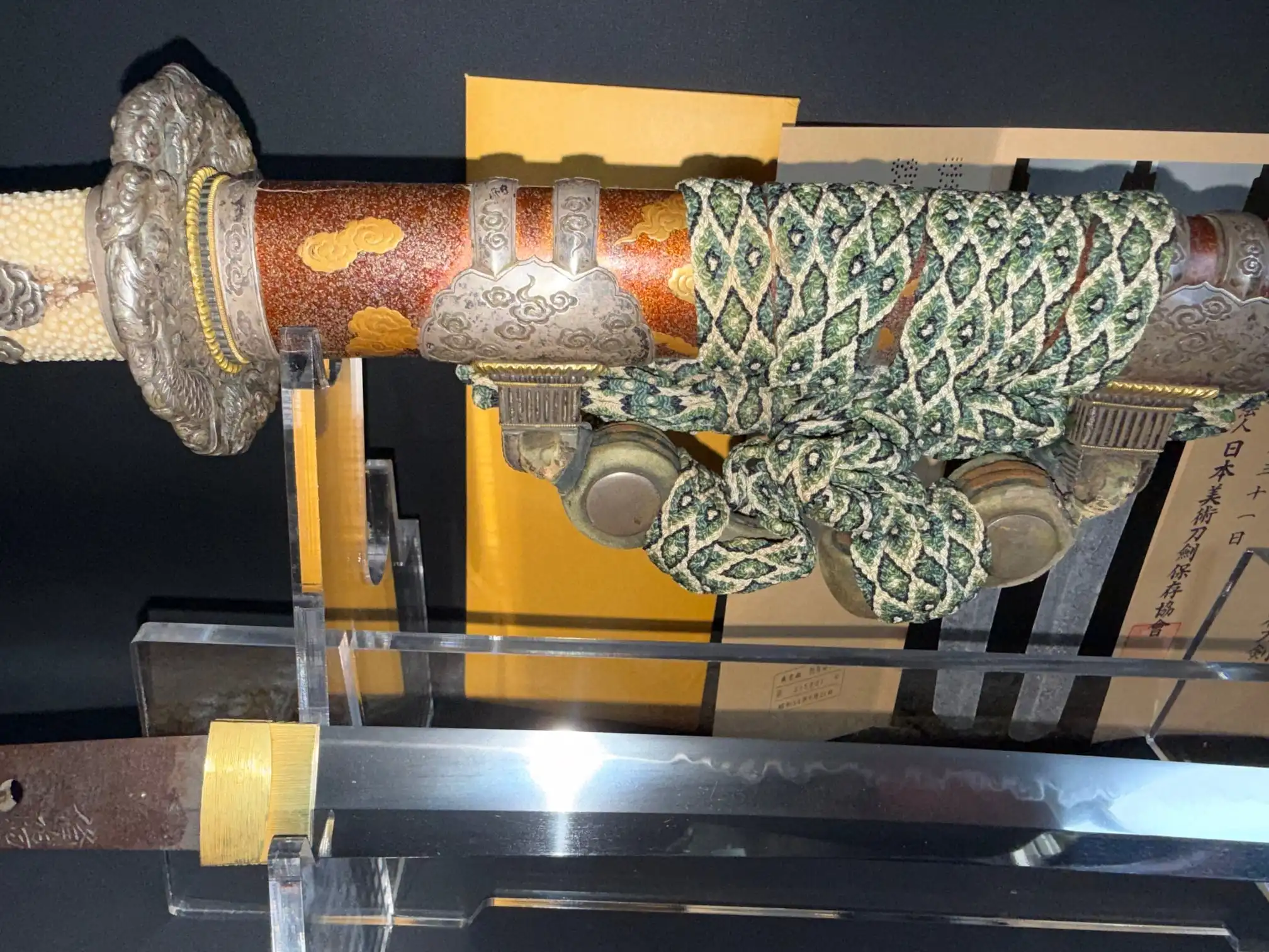 Tachi Yokoyama Sukekane Katana with ornate red scabbard, detailed hilt, and visible hamon blade edge.