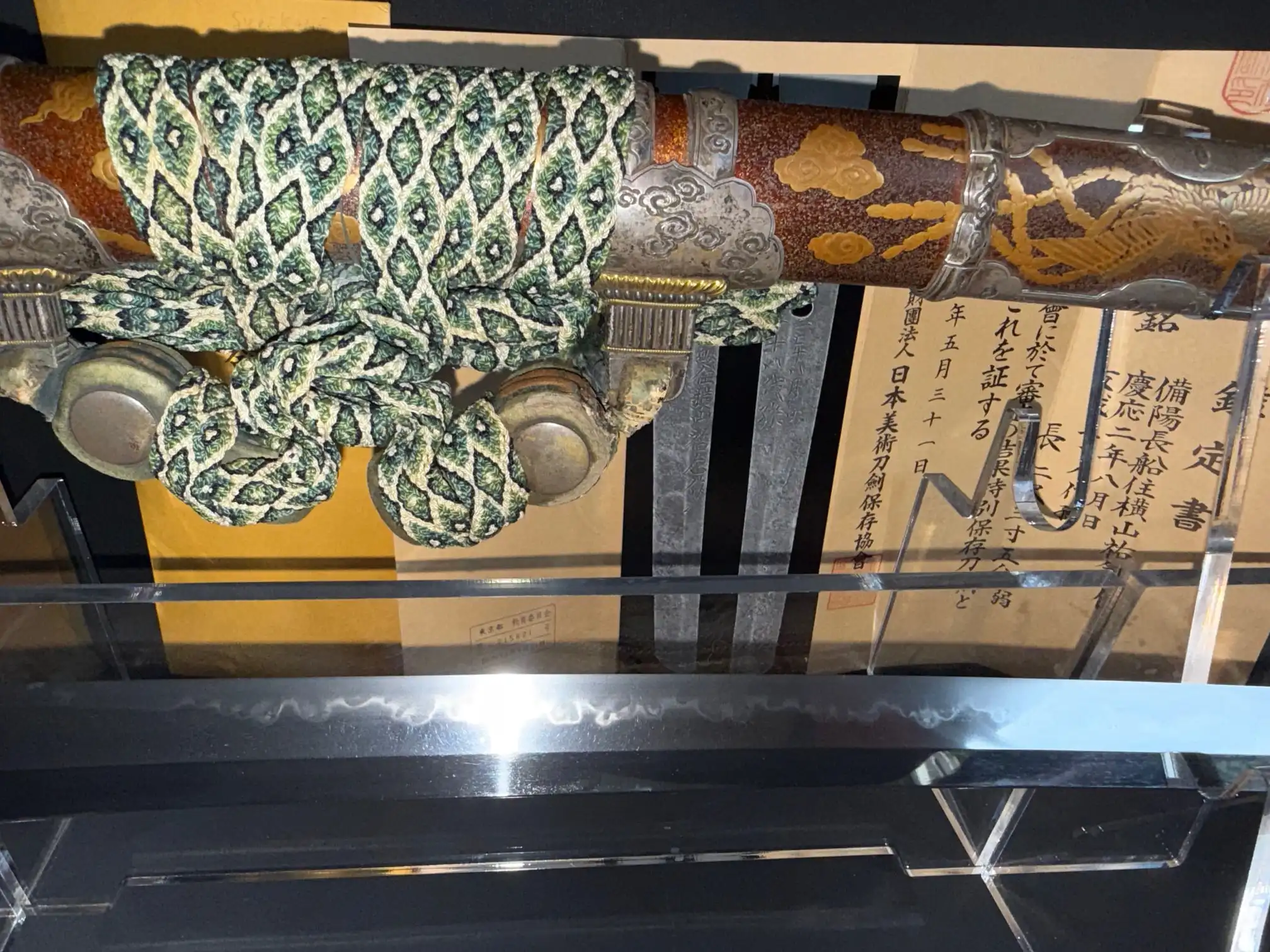 Close-up, top-down of an antique Tachi Yokoyama Sukekane Katana with ornate saya and blade evident.