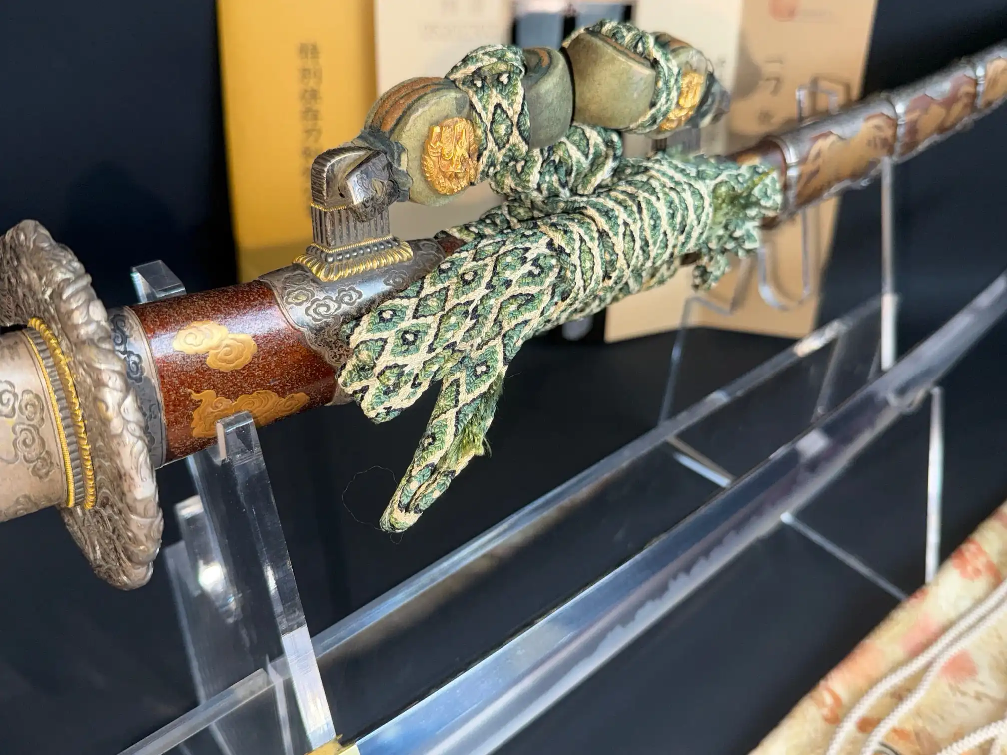 Close-up of a Katana, the Tachi Yokoyama Sukekane (1866) intricate hilt and part of the gleaming blade, from above.