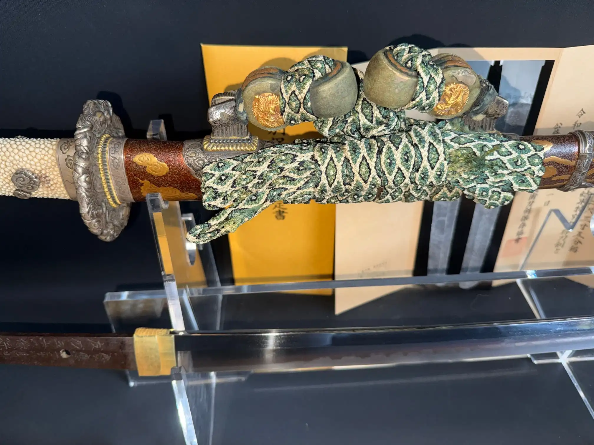 Tachi Yokoyama Sukekane Katana with ornate red and gold saya, ray skin tsuka, and green wrapped handle.