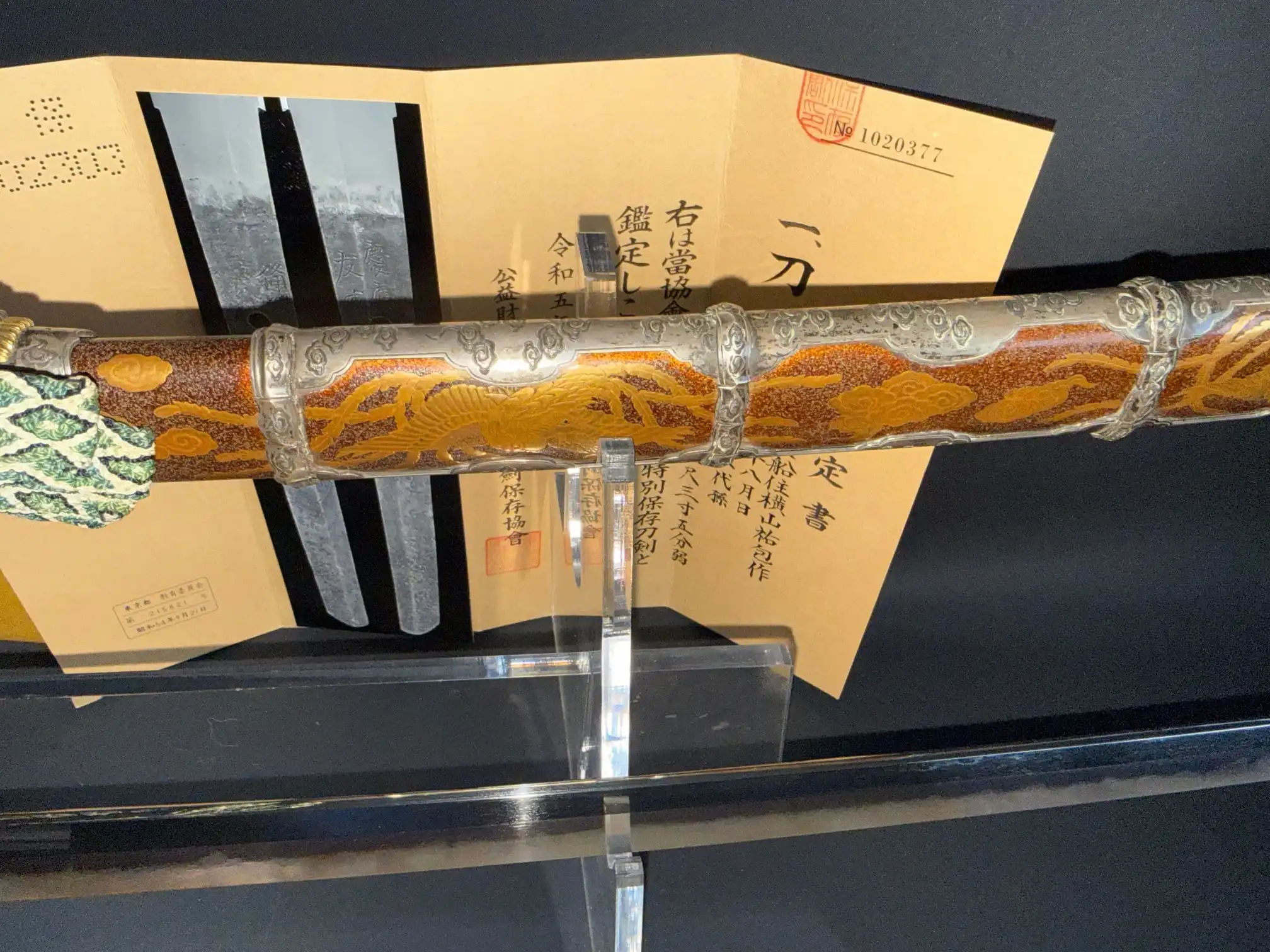 Tachi Yokoyama Sukekane Katana with ornate scabbard on display with appraisal paperwork.