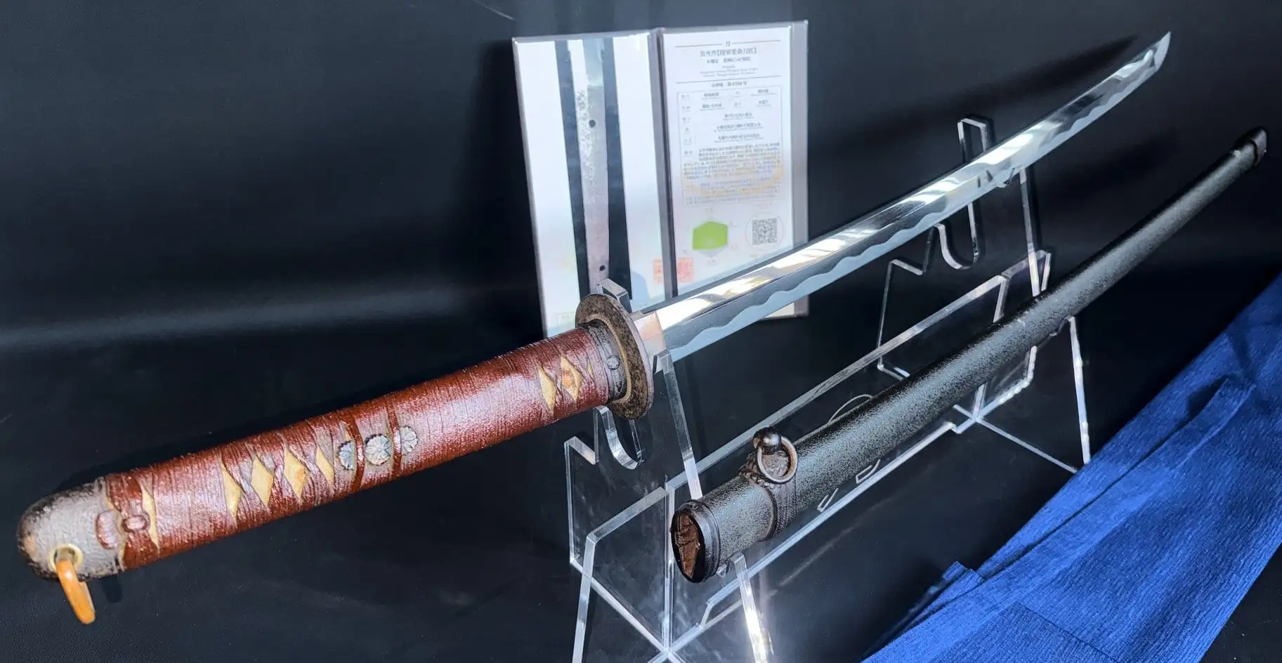 Long view of WWII Katana Ichihara Nagamitsu on display, showing brown wrapped handle, scabbard, and curved blade
