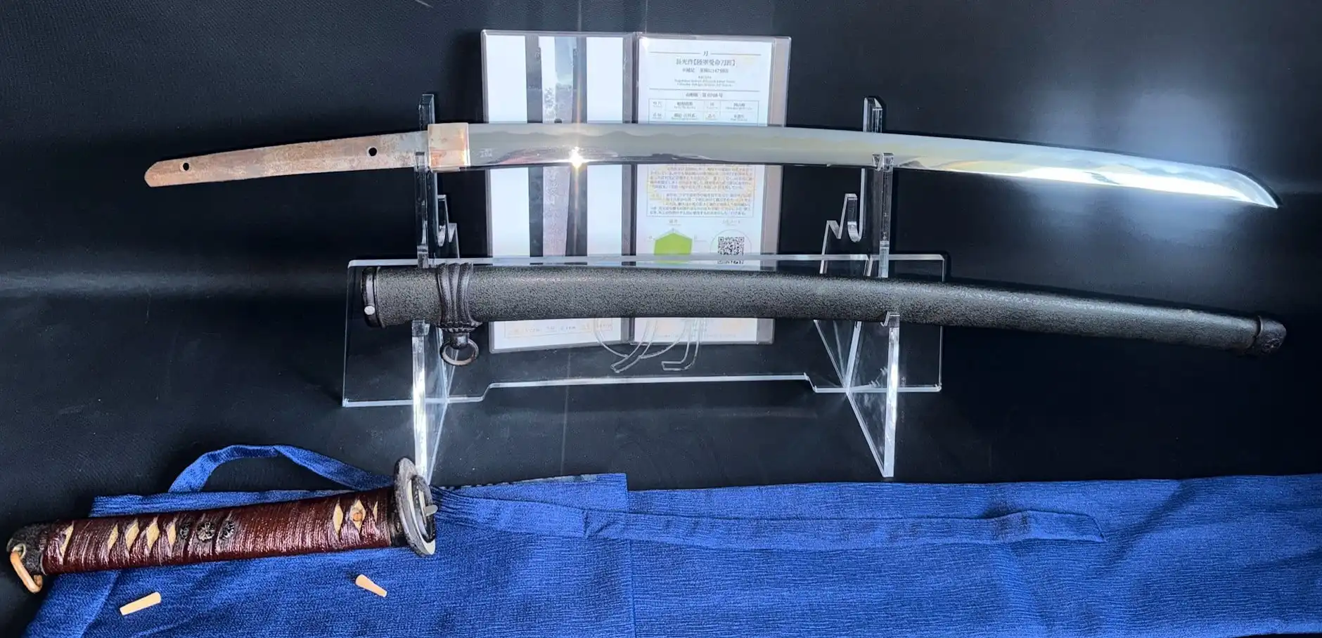 WWII Katana Ichihara Nagamitsu blade on stand, scabbard below on display, tang visible.