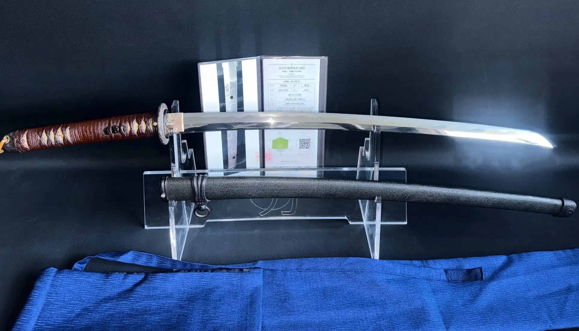WWII Katana Ichihara Nagamitsu displayed horizontally with scabbard below, documentation stands behind