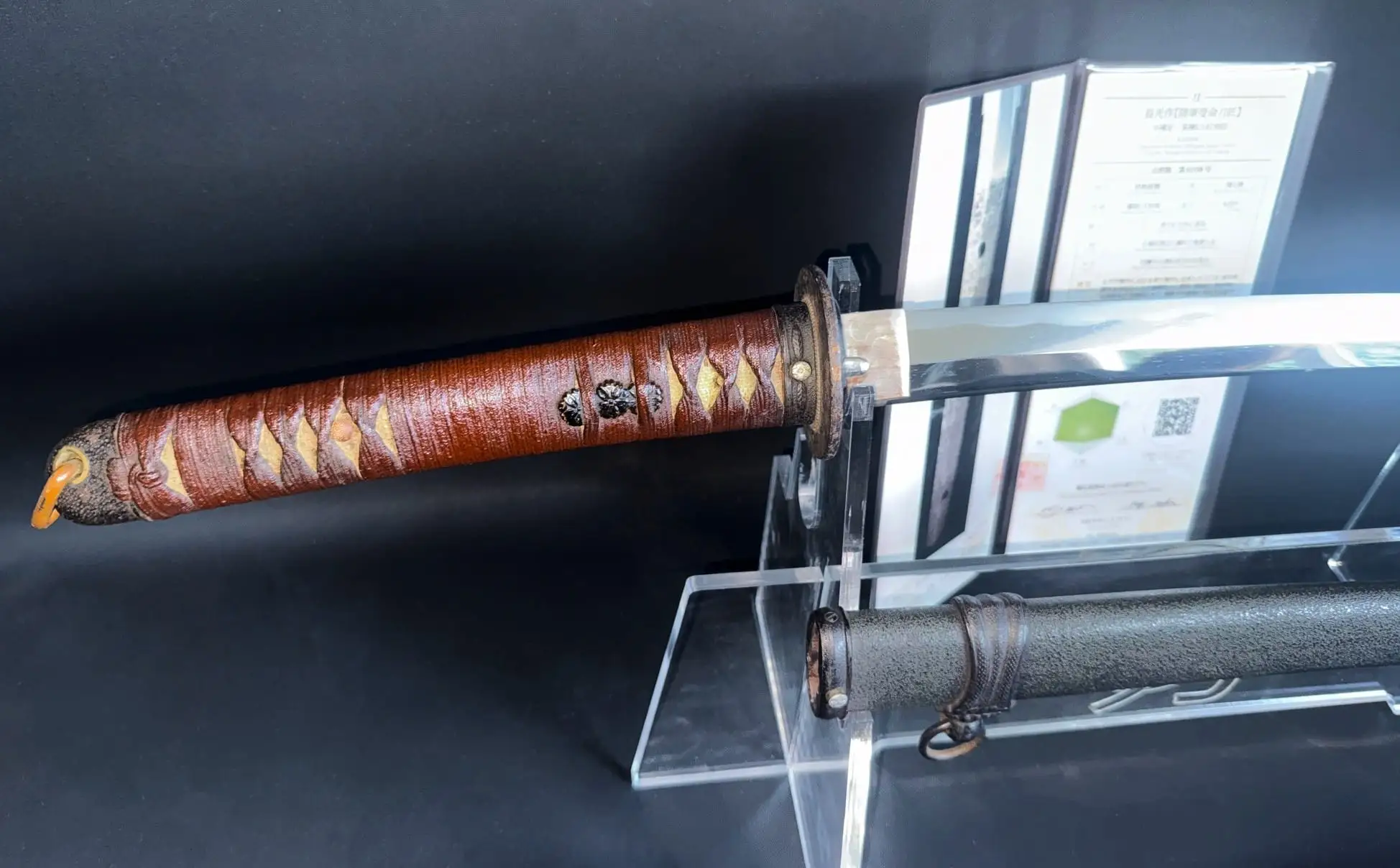 WWII Katana Ichihara Nagamitsu with brown wrapped tsuka and polished blade, displayed on stand