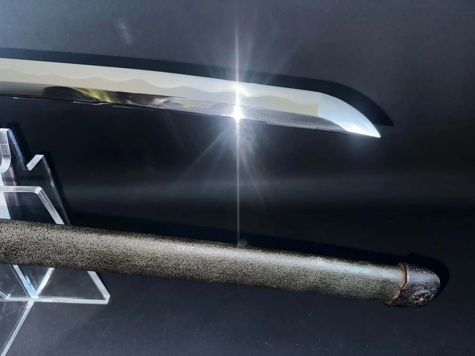 Close-up of a WWII Katana Ichihara Nagamitsu blade with prominent hamon and textured saya.