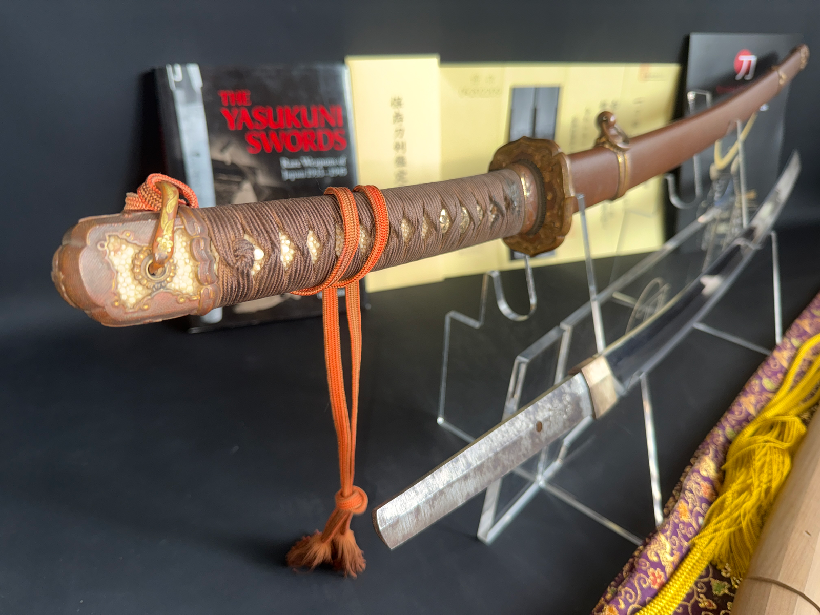Close-up of a Yasukuni Gendaitō Yasunobu katana, showing its detailed handle and part of the blade.