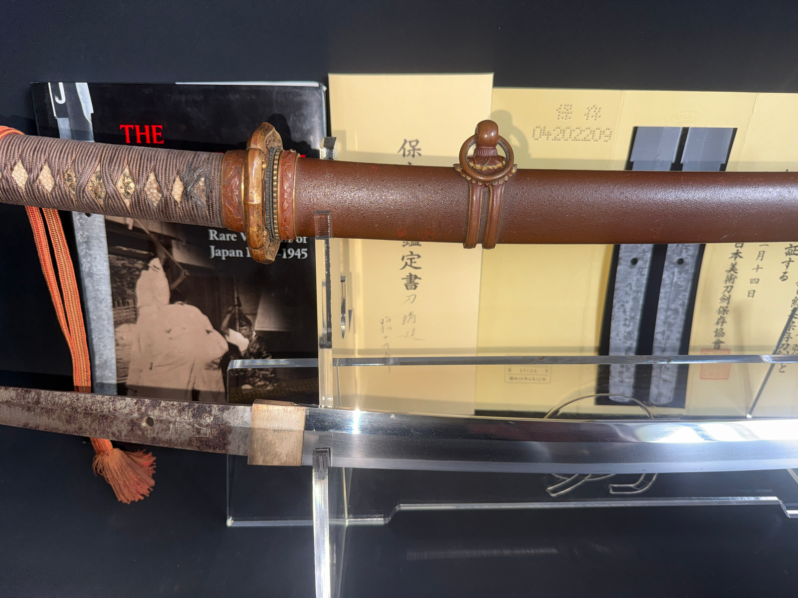 Yasukuni Gendaitō Yasunobu katana with visible tang and habaki, hilt tsuka and brown lacquered saya.