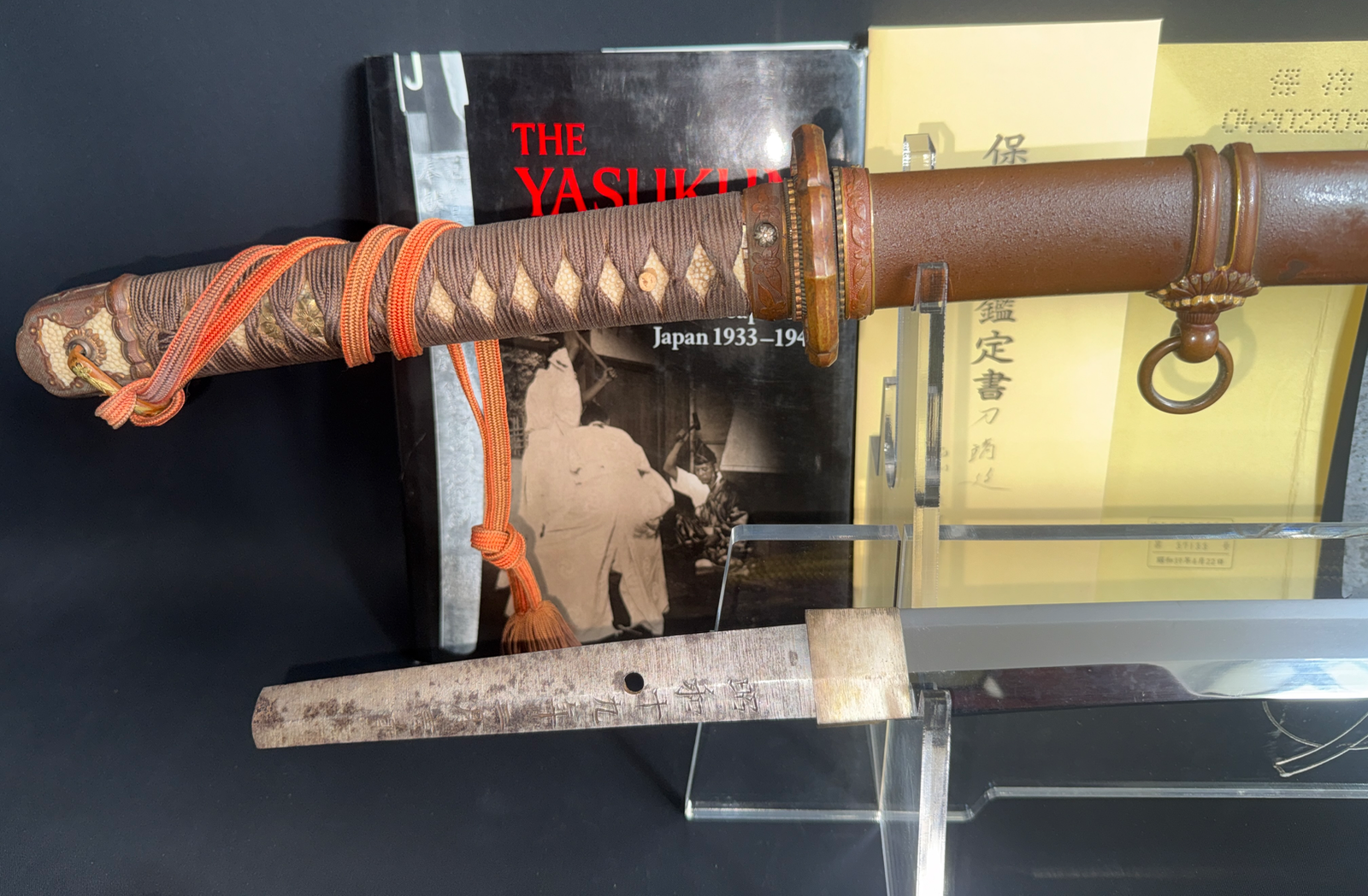 Yasukuni Gendaitō Yasunobu Katana with detailed brown hilt binding, shown with documents