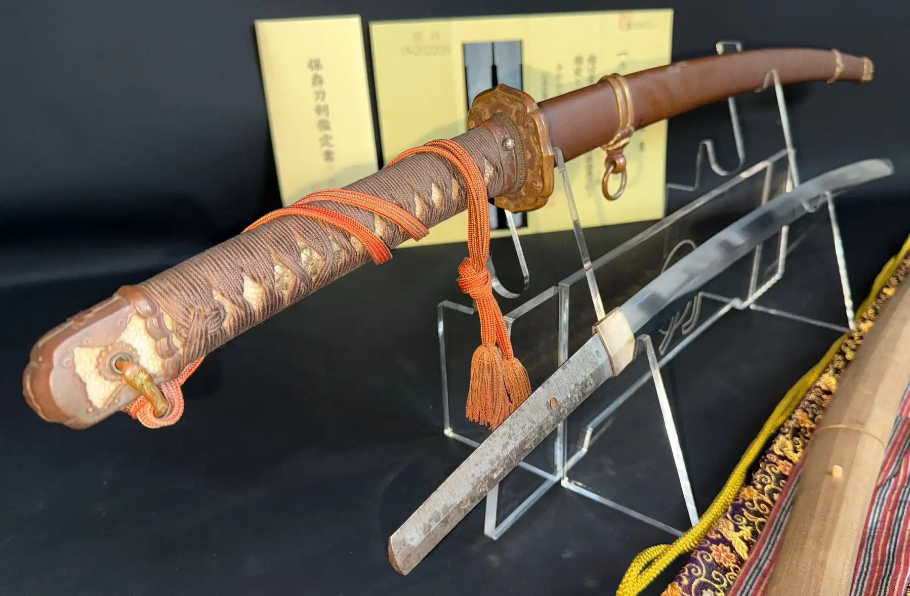 Yasukuni Gendaitō Yasunobu katana with scabbard, hilt with orange cord, and exposed blade on display