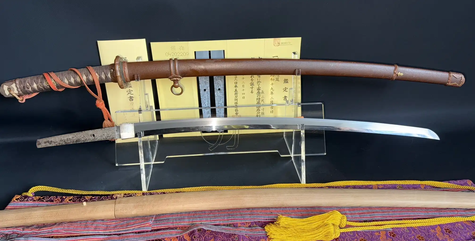 Yasukuni Gendaitō Yasunobu katana with scabbard, presented gleaming on clear stands
