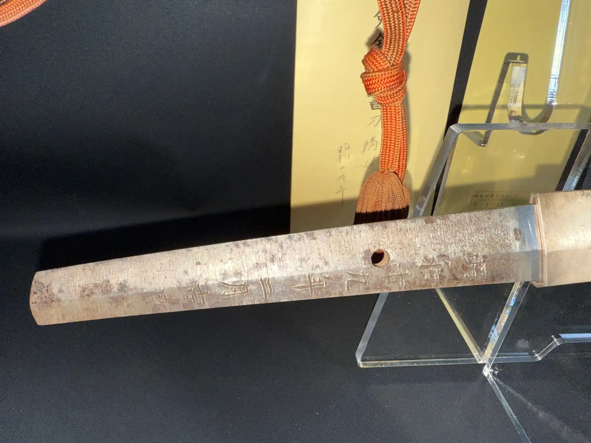 Close-up of a Yasukuni Gendaitō Yasunobu katana tang with engraved kanji and a single mekugi-ana hole.