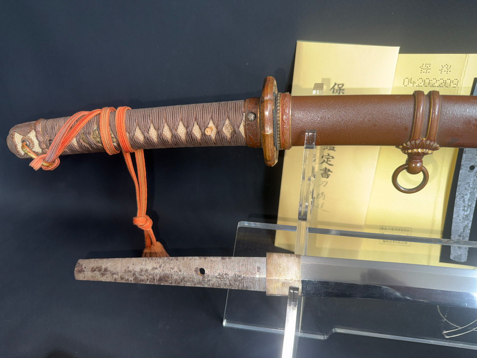 Yasukuni Gendaitō Yasunobu katana with visible nagako, hilt, scabbard and document in background