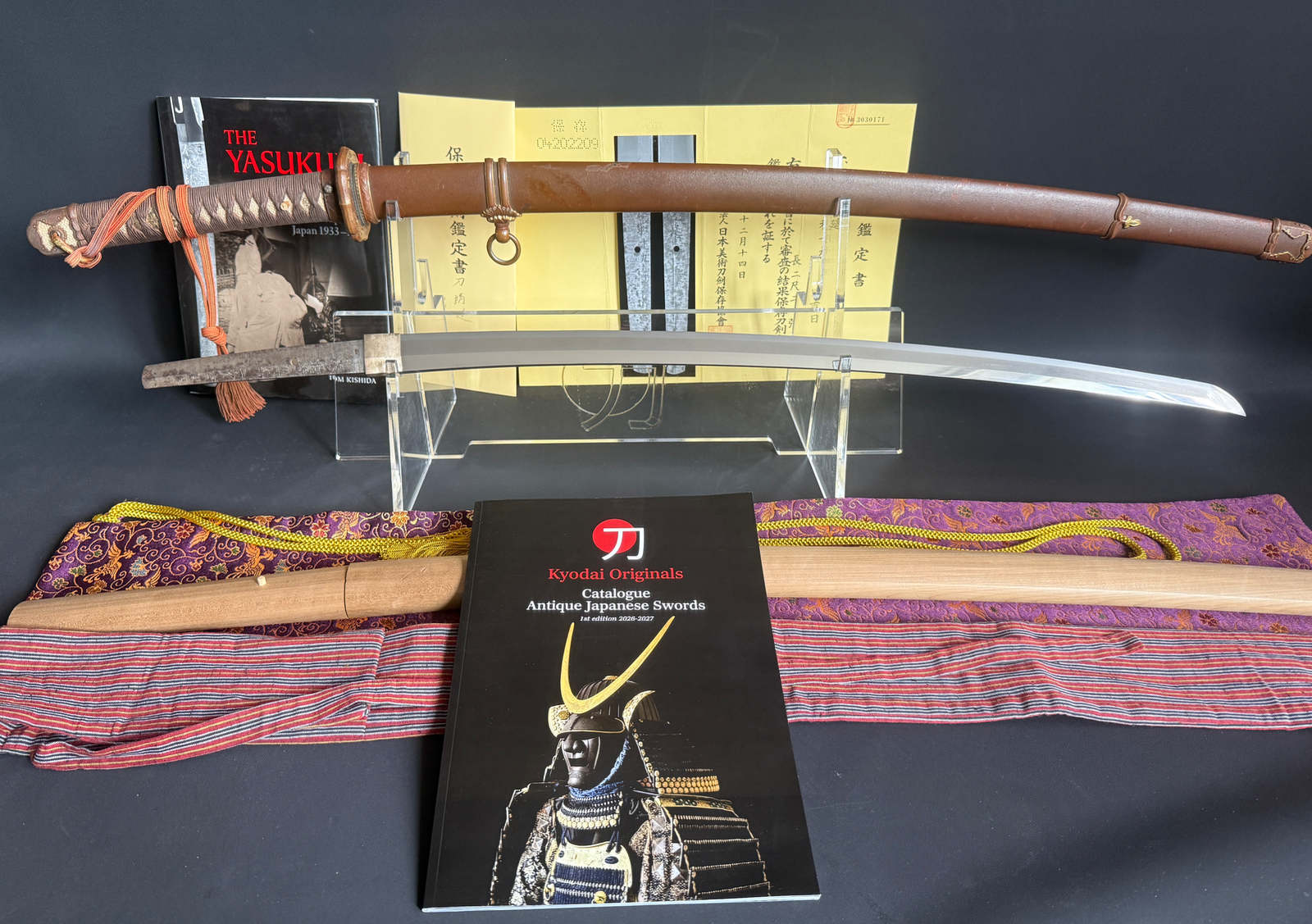 Yasukuni Gendaitō Yasunobu katana with scabbard, blade, and accessories on display