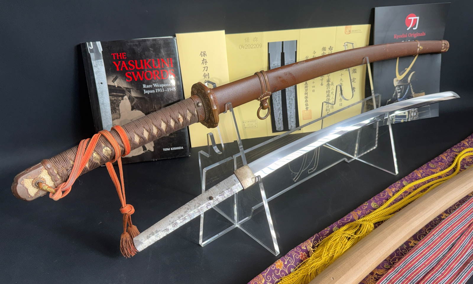 Yasukuni Gendaitō Yasunobu katana with scabbard, presented on a stand with reference books