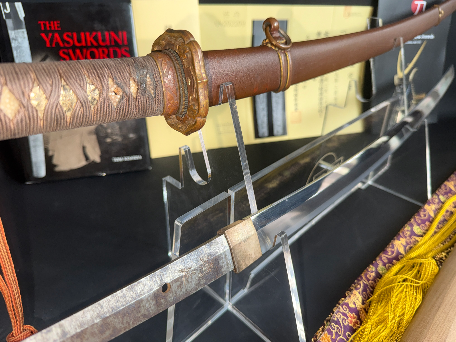 Close-up angled view of a Yasukuni Gendaitō Yasunobu katana, its tang with visible signature displayed