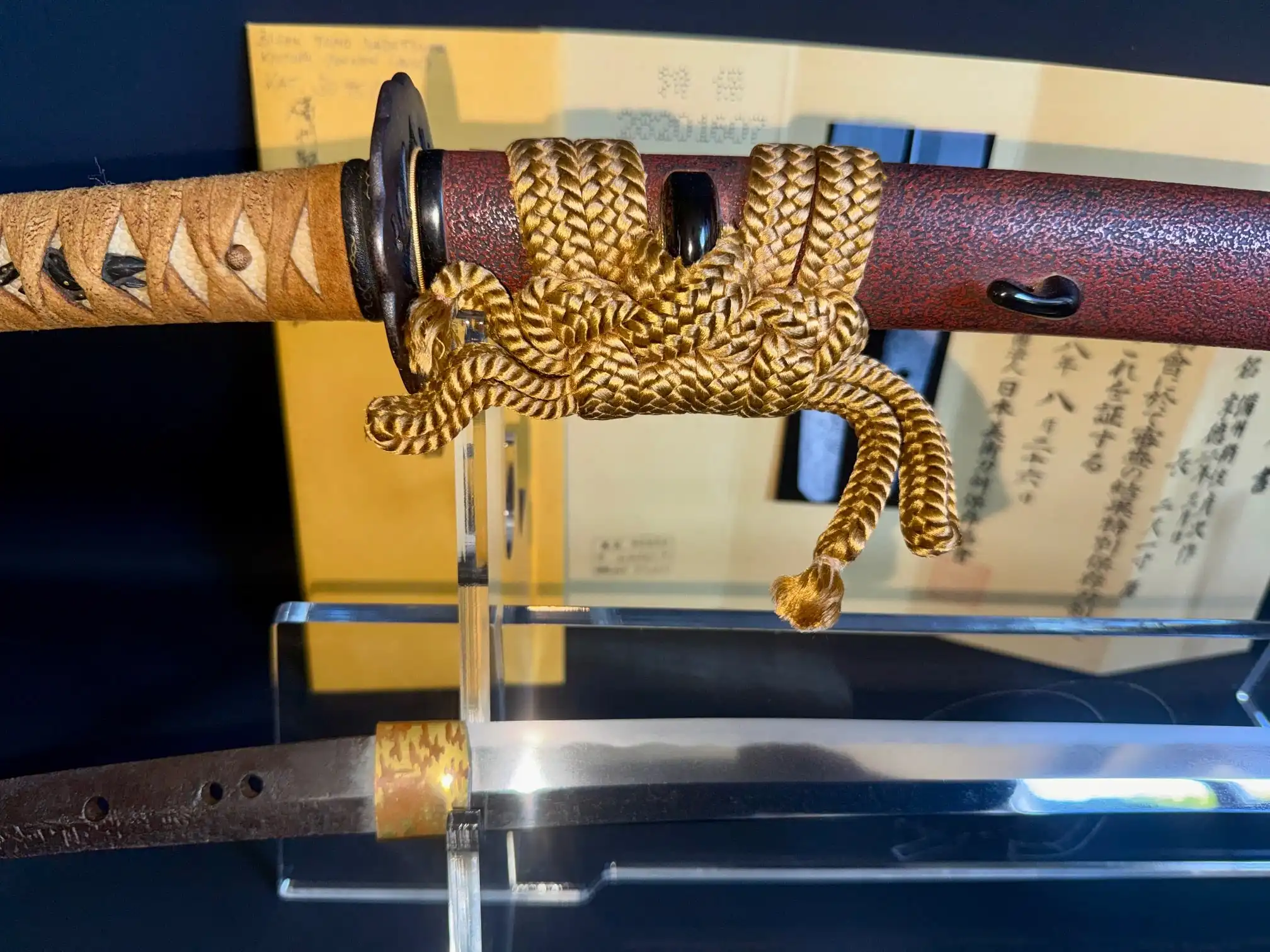 Close-up of Katana Bishū Tomo-jū Sadatsugu, showing intricate gold sageo, scabbard, and blade.
