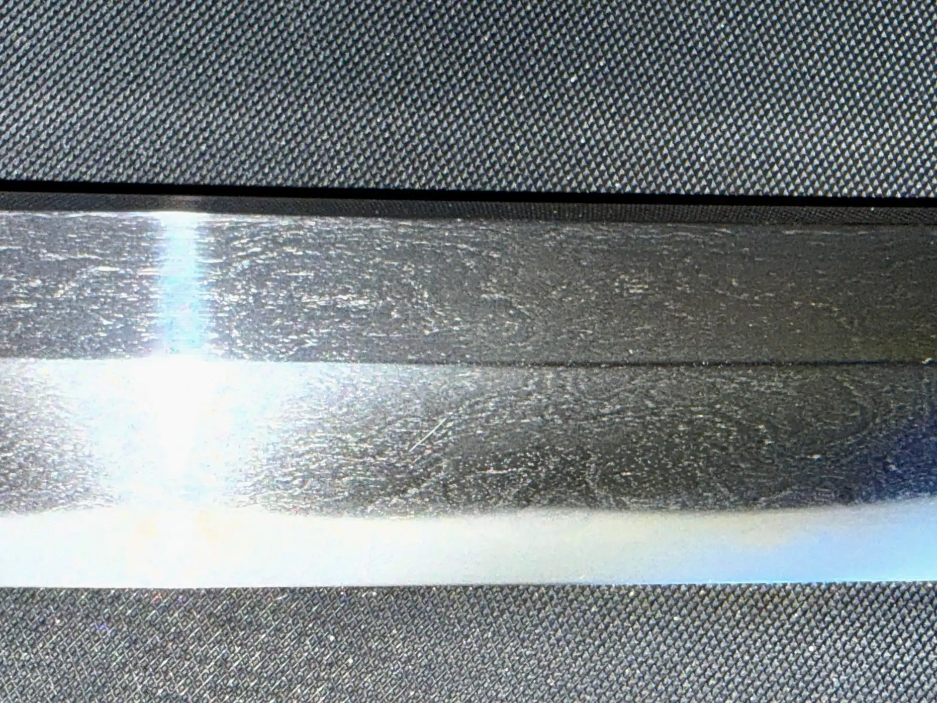 Close up, the hamon (temper line) of the Katana Bishū Tomo-jū Sadatsugu blade displays intricate patterns