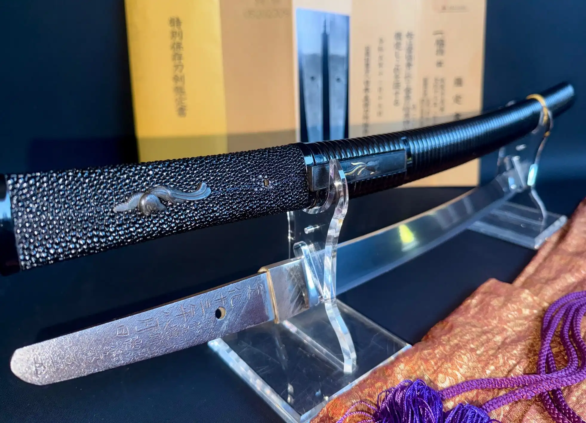 Suishinshi Masahide Wakizashi in black saya with exposed tang, displayed on a stand.