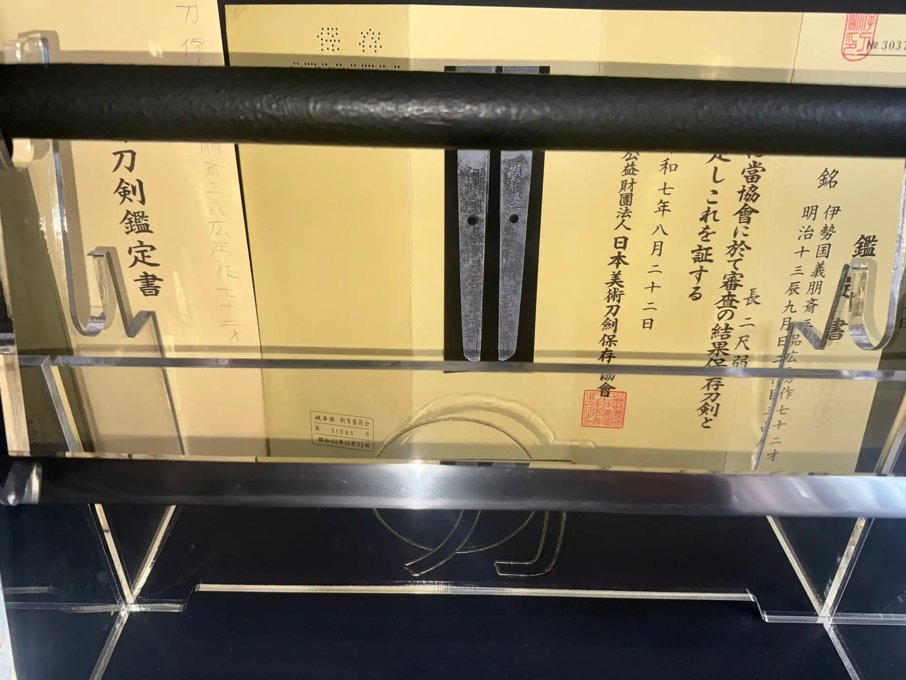 Top-down view of a Shikomizue Sword by Giho-sai Hirofusa katana with papers framed, showing the tang.