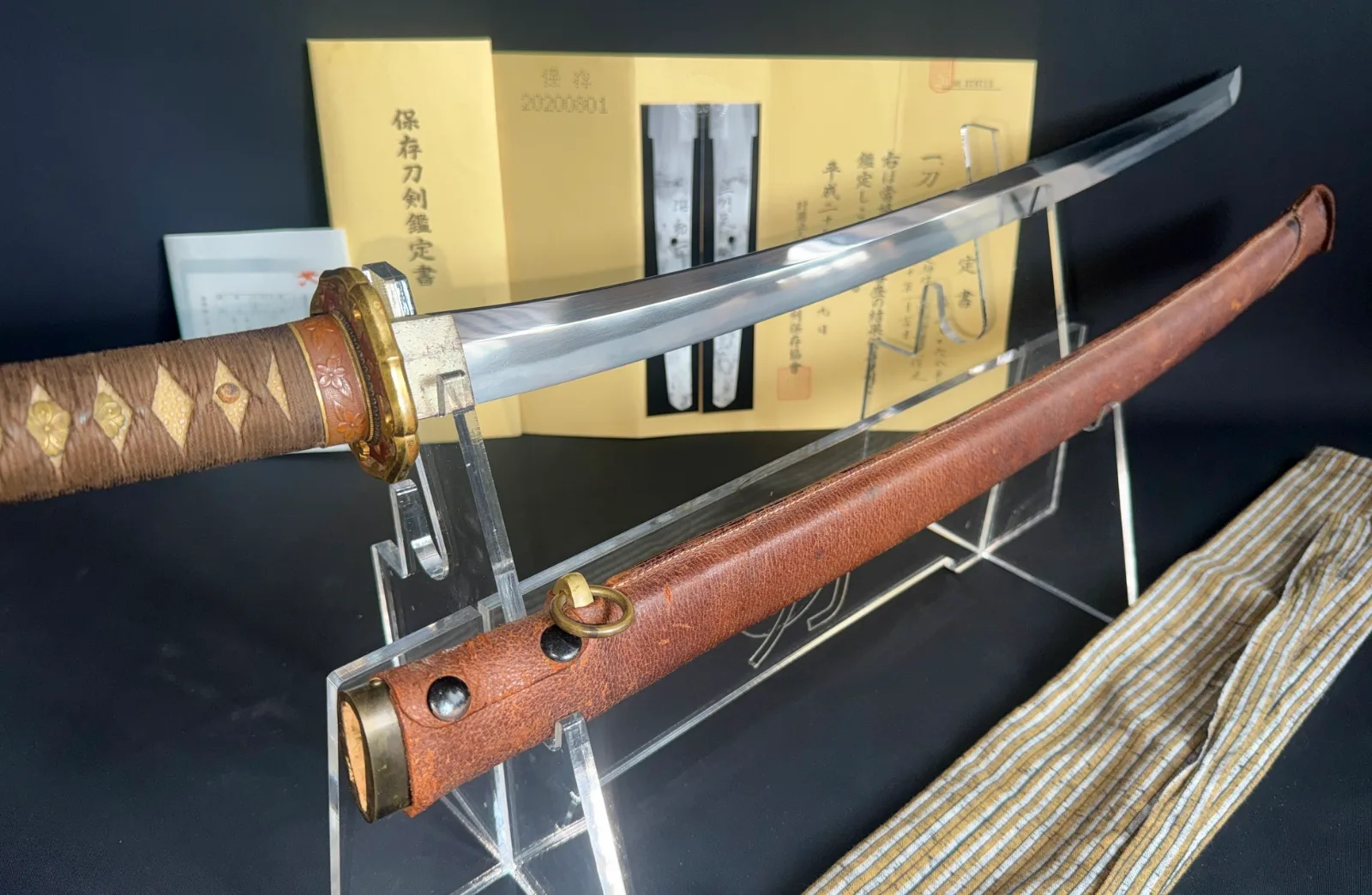 Chōunsai Shigemitsu Katana 1945, polished blade, wrapped handle, brown leather saya, and NBTHK certificate