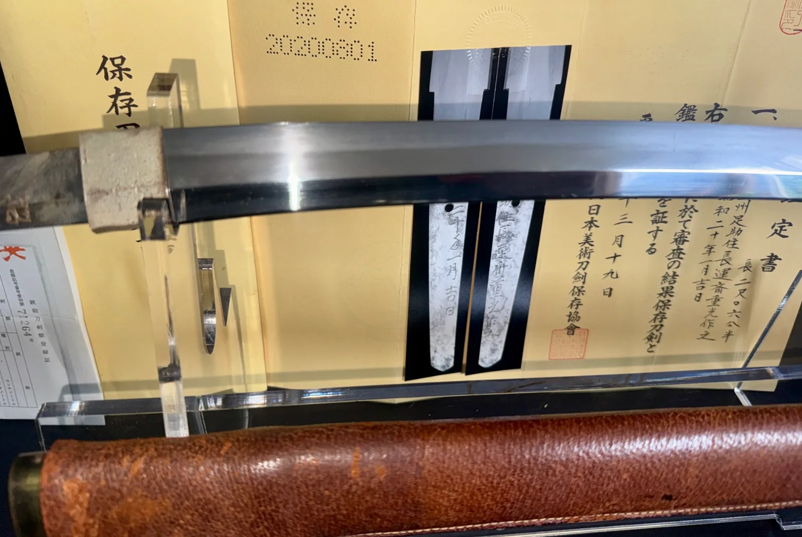 Close up of a Chōunsai Shigemitsu Katana (1945) samurai sword blade, tangs, and scabbard.